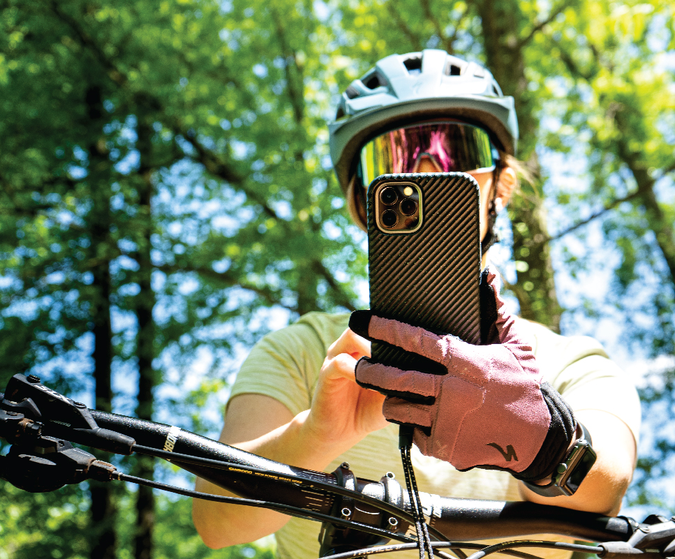 Cyclist holding phone and taking pictures on a mountain bike