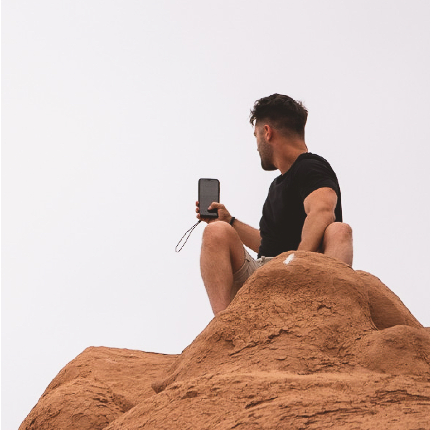 Man using phone on a rock with Sego case