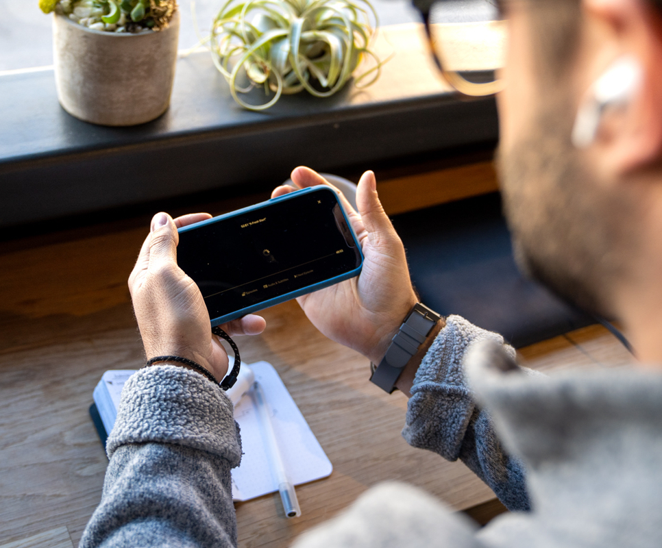 Playing a game on mobile phone with protective case and lanyard